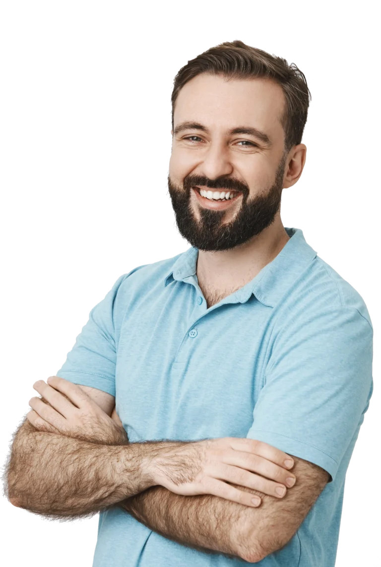 Indoor portrait of attractive adult man with beard and shiny smile, standing over gray background half-turned with crossed arms. Guy assures with his look that he is reliable and very grounded.