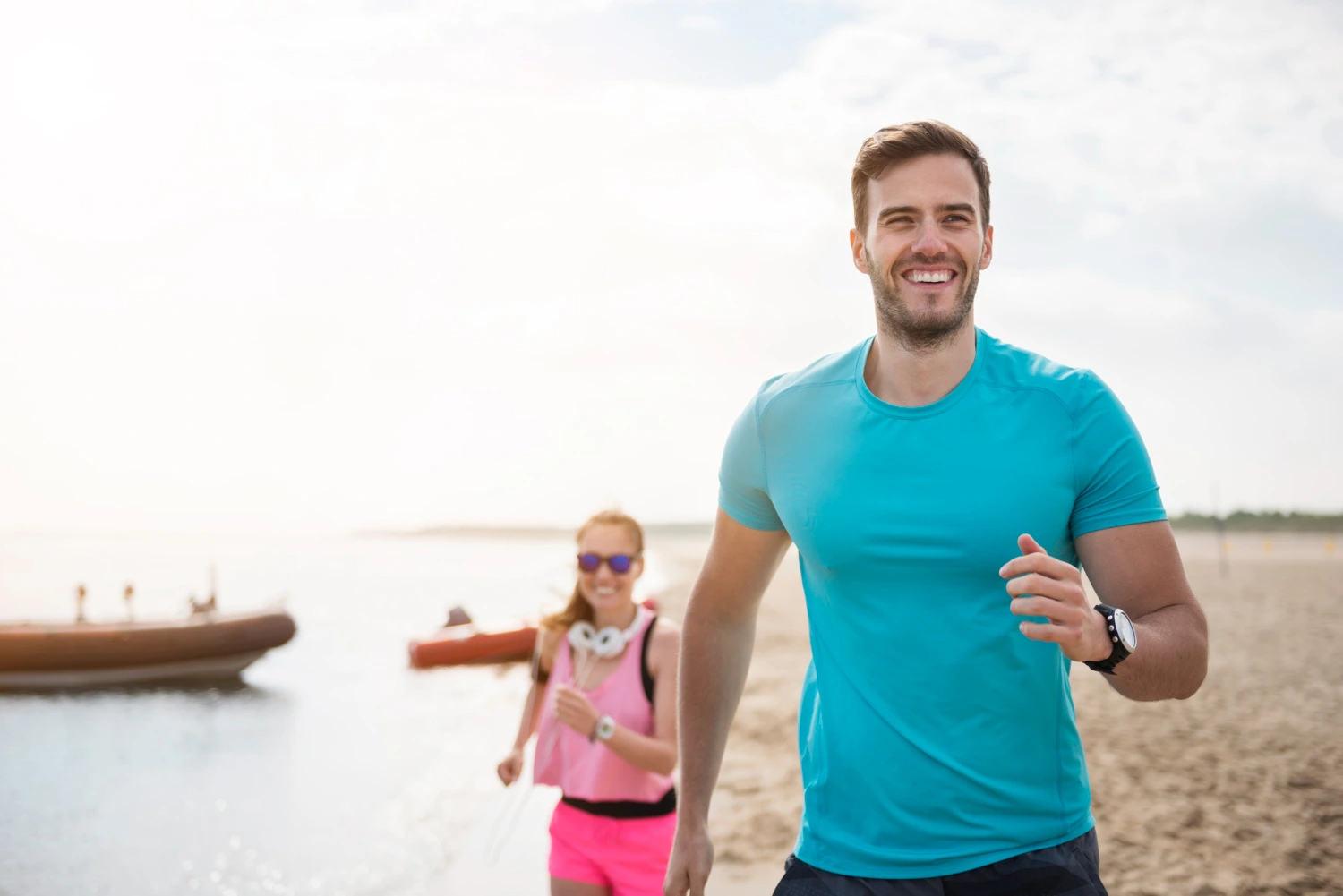 Close up young fit people jogging by sea